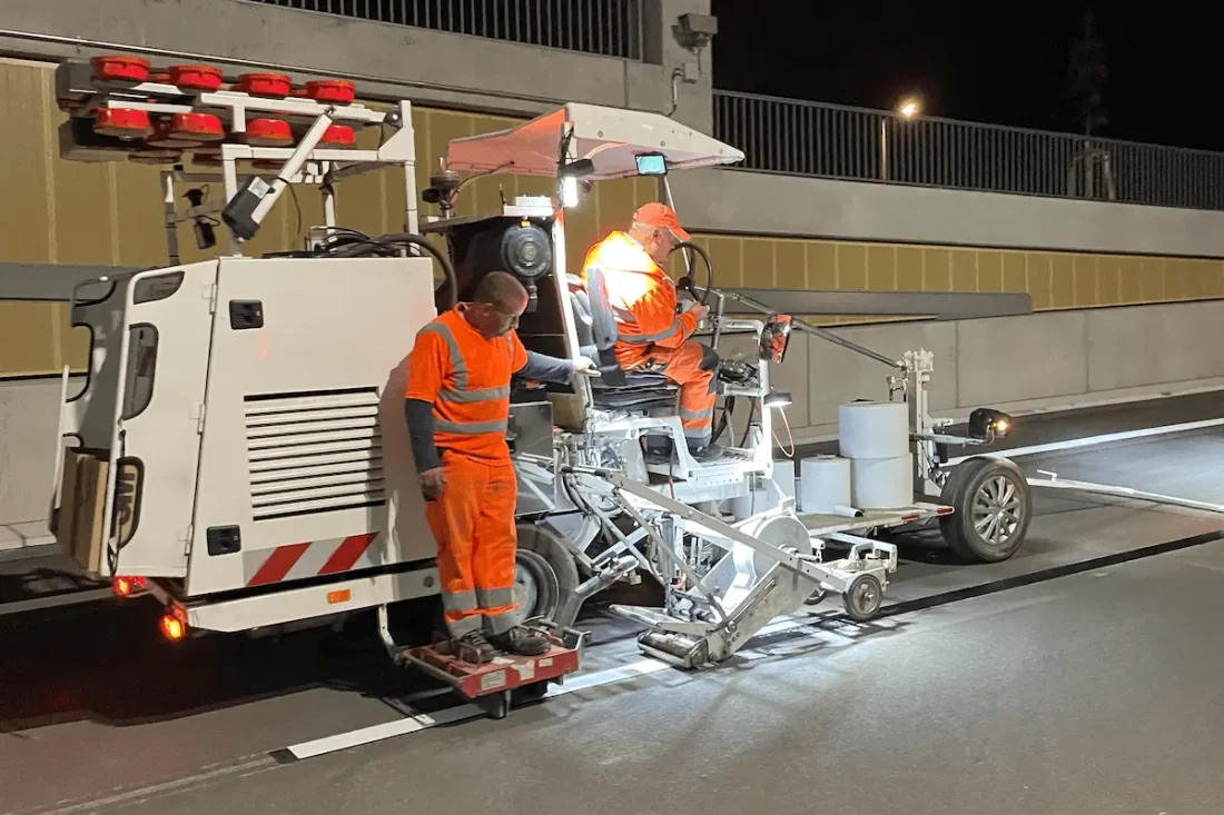 Mitarbeiter der NTC Markierung markieren eine Straße bei Nacht